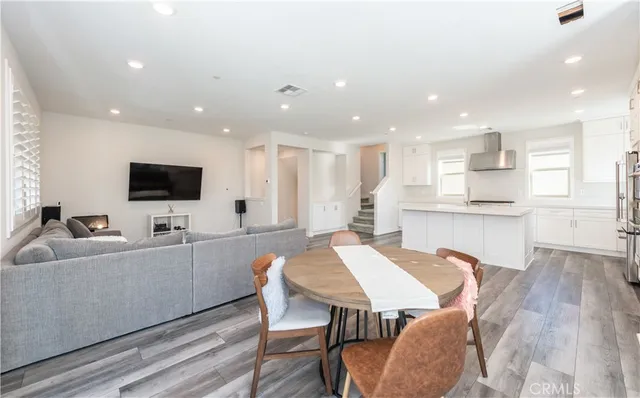 a living room with stainless steel appliances furniture and a flat screen tv