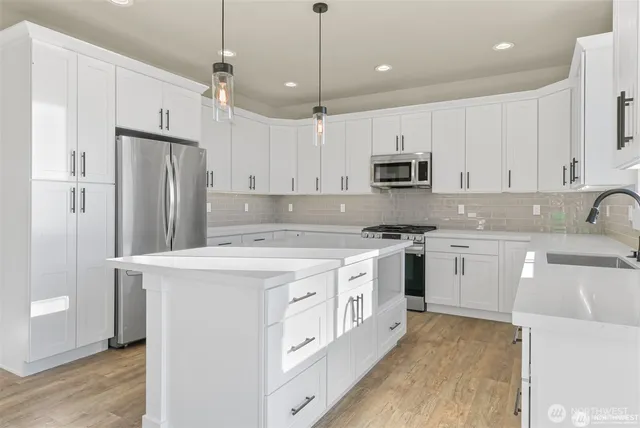 a kitchen with stainless steel appliances granite countertop a refrigerator a stove a sink and white cabinets