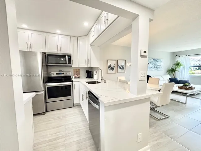a kitchen with white cabinets and stainless steel appliances