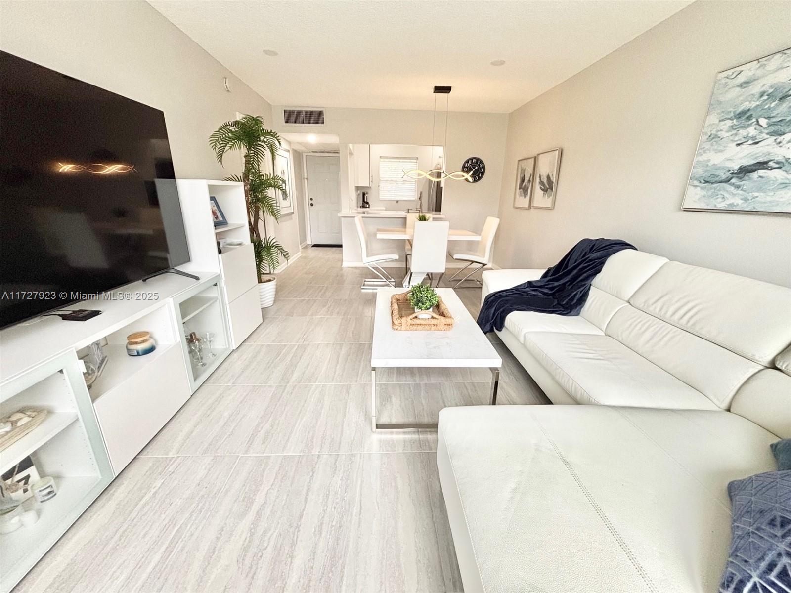 3405 Northwest 48th Avenue, Unit 407 Lauderdale Lakes, FL 33319 - Photo 14 of 44 a living room with furniture and a flat screen tv