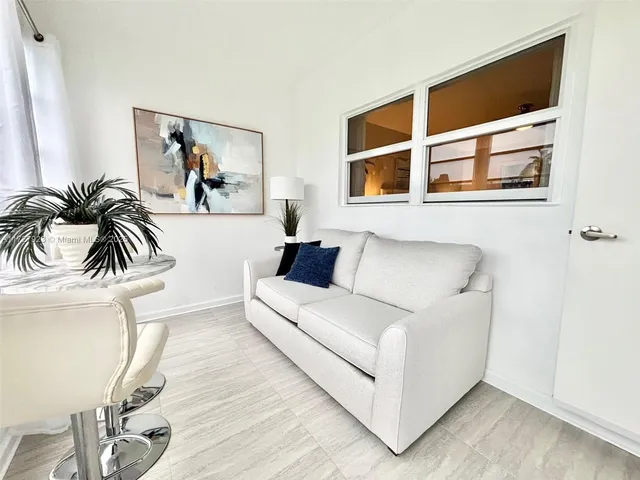 a view of a livingroom with furniture window and wooden floor