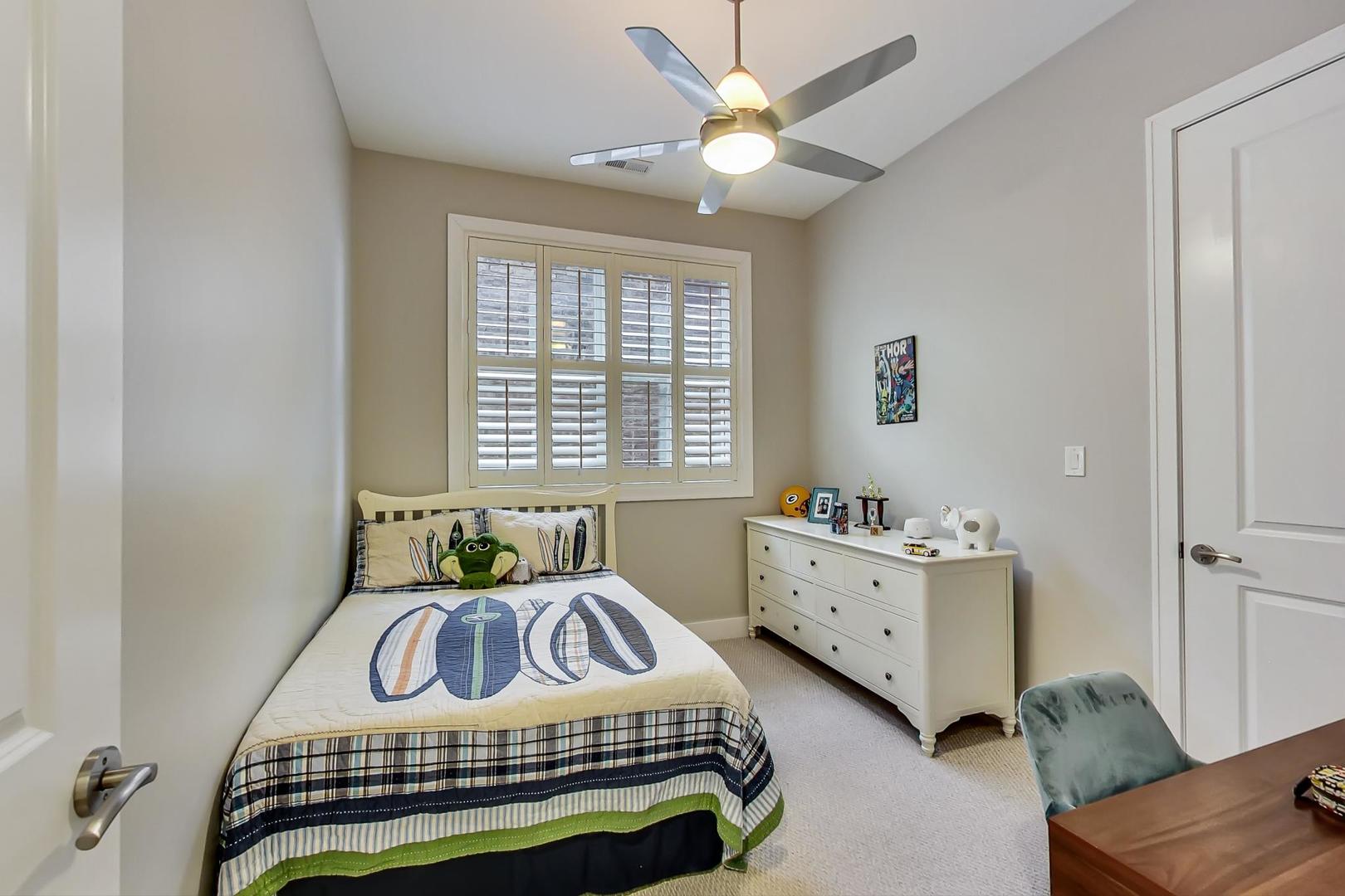 2121 West Roscoe Street, Unit 2 Chicago, IL 60618 - Photo 21 of 24 a bedroom with a bed and a chandelier