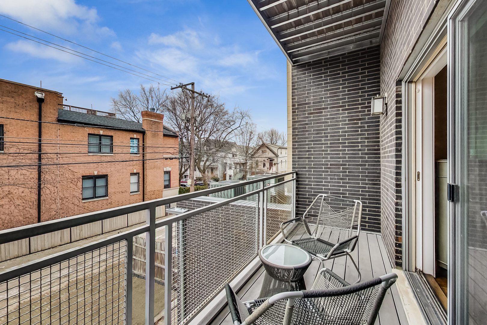 2121 West Roscoe Street, Unit 2 Chicago, IL 60618 - Photo 23 of 24 a view of a balcony with chair and wooden fence