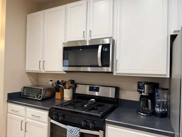 a kitchen with stainless steel appliances granite countertop a stove a sink and a refrigerator