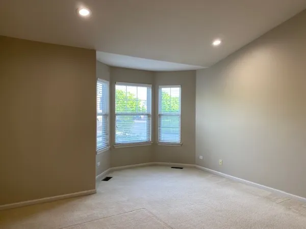 an empty room with closet and a hallway