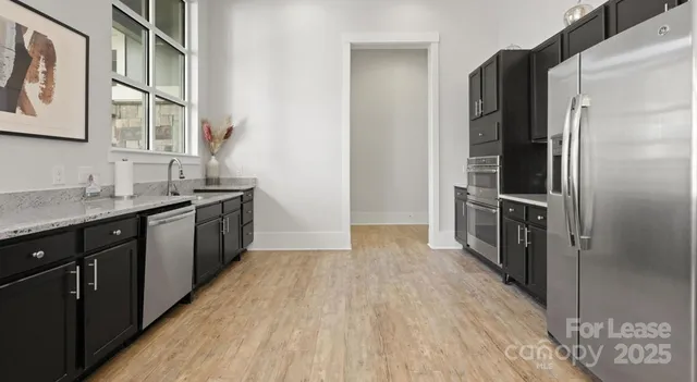 a kitchen with stainless steel appliances granite countertop a refrigerator and a sink