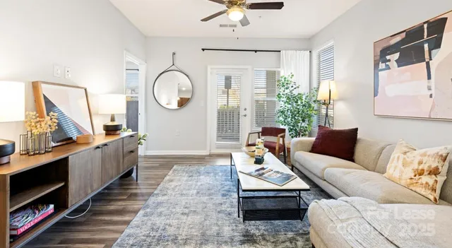 a living room with furniture wooden floor and a large window