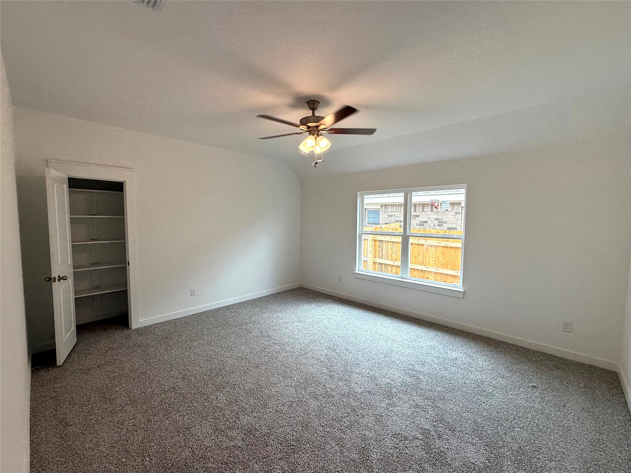 13615 Barn Chime Street Elgin, TX 78621 - Photo 5 of 8 an empty room with a window and a ceiling fan