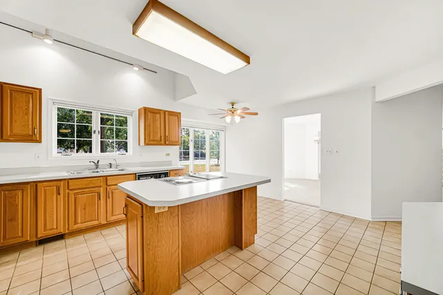 a large kitchen with granite countertop a stove a sink dishwasher and a refrigerator