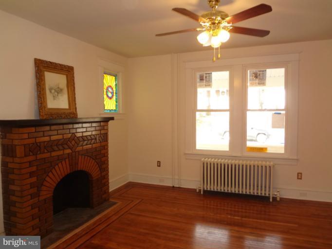 644 Coleraine Road Baltimore, MD 21229 - Photo 29 of 30 a living room with a fireplace windows and a chandelier