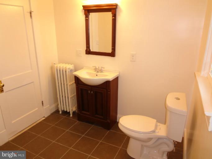 644 Coleraine Road Baltimore, MD 21229 - Photo 6 of 30 a bathroom with a toilet a sink and mirror