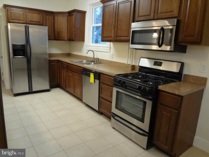 644 Coleraine Road Baltimore, MD 21229 - Photo 8 of 30 a kitchen with stainless steel appliances granite countertop a stove microwave and refrigerator