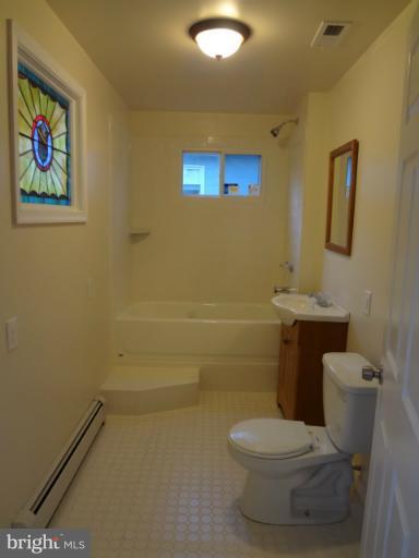644 Coleraine Road Baltimore, MD 21229 - Photo 9 of 30 a white toilet sitting next to a bathroom sink and vanity