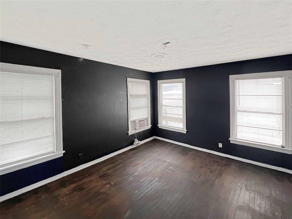 1010 Winters Street Dallas, TX 75216 - Photo 11 of 20 Room featuring dark wall paint, white trim, and wood-finish flooring