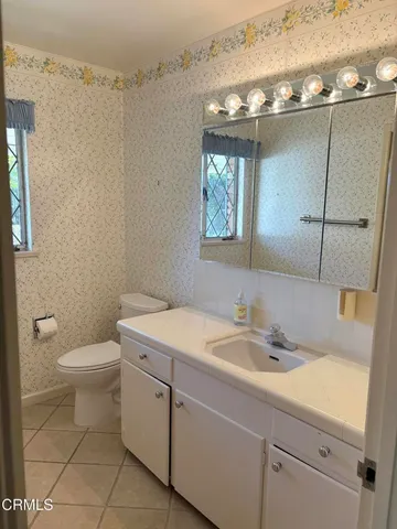 a bathroom with a sink a toilet and mirror