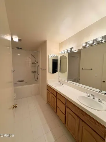 a spacious bathroom with a tub sink and mirror