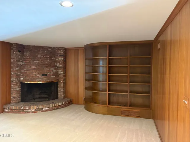 a view of an empty room with a fireplace and a window