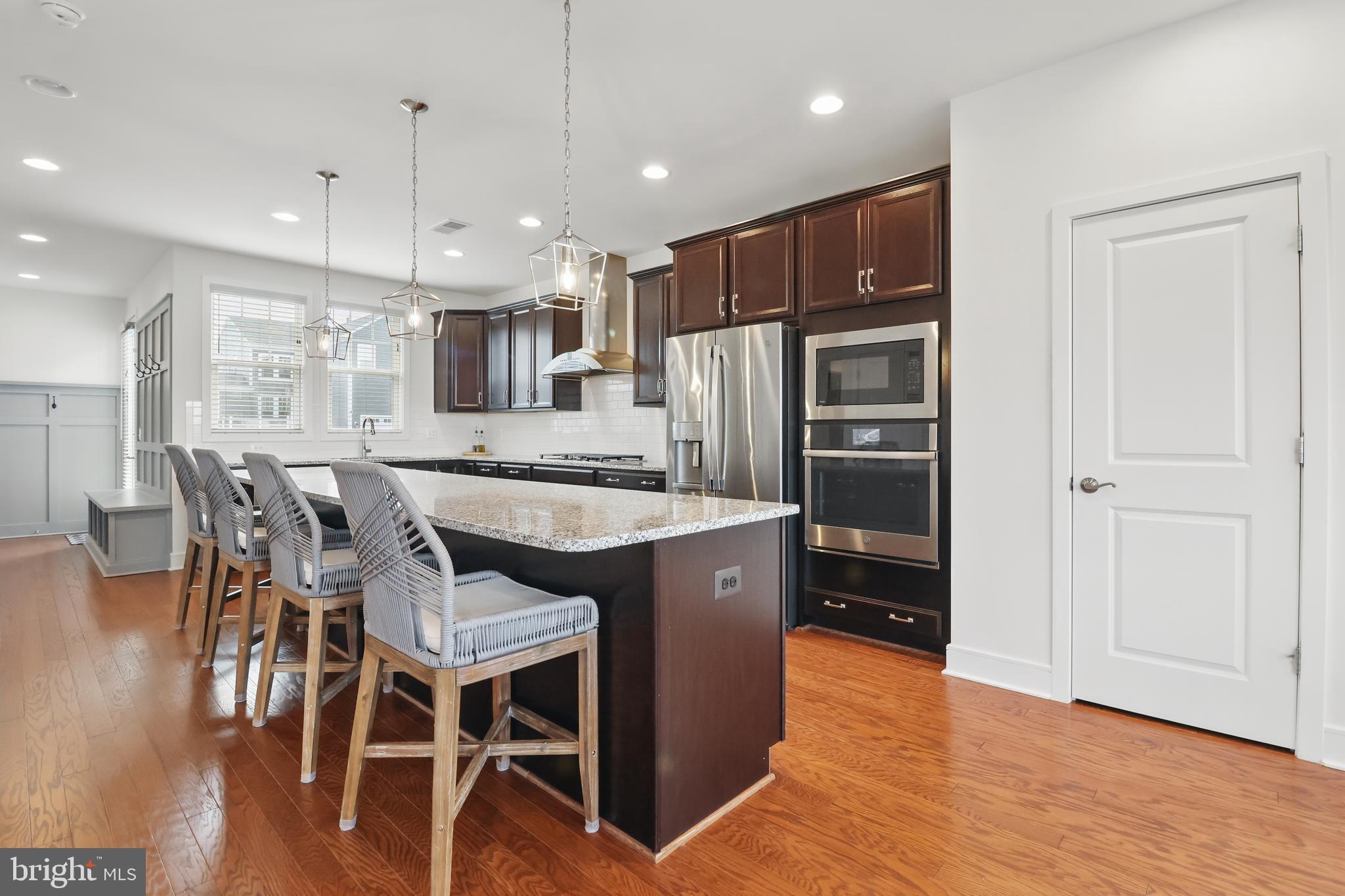 1010 Coubertin Drive Southeast Leesburg, VA 20175 - Photo 18 of 44 a kitchen with stainless steel appliances granite countertop a refrigerator a stove a sink a dining table and chairs with wooden floor