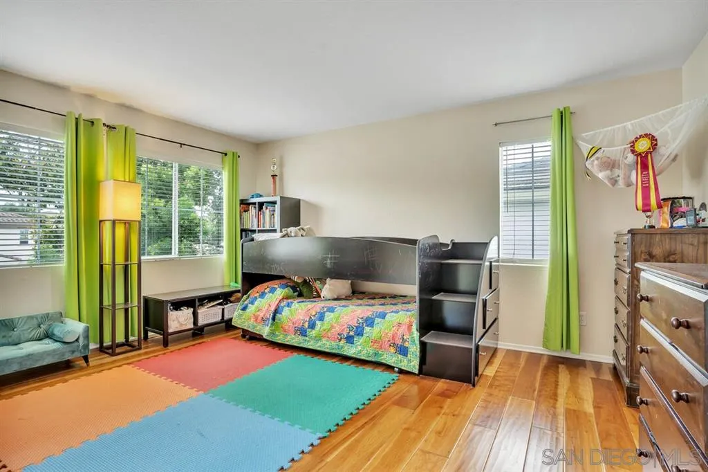 1103 Greenway Road Oceanside, CA 92057 - Photo 18 of 25 a bedroom with a bed and a wooden floor