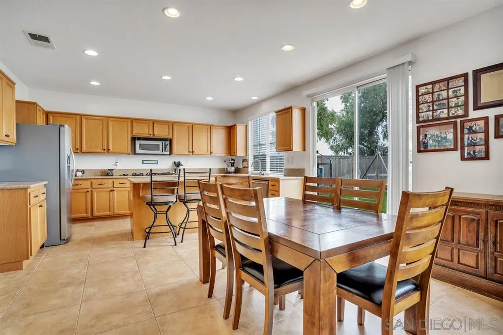 1103 Greenway Road Oceanside, CA 92057 - Photo 8 of 25 a dining room with stainless steel appliances kitchen island granite countertop a dining table and chairs