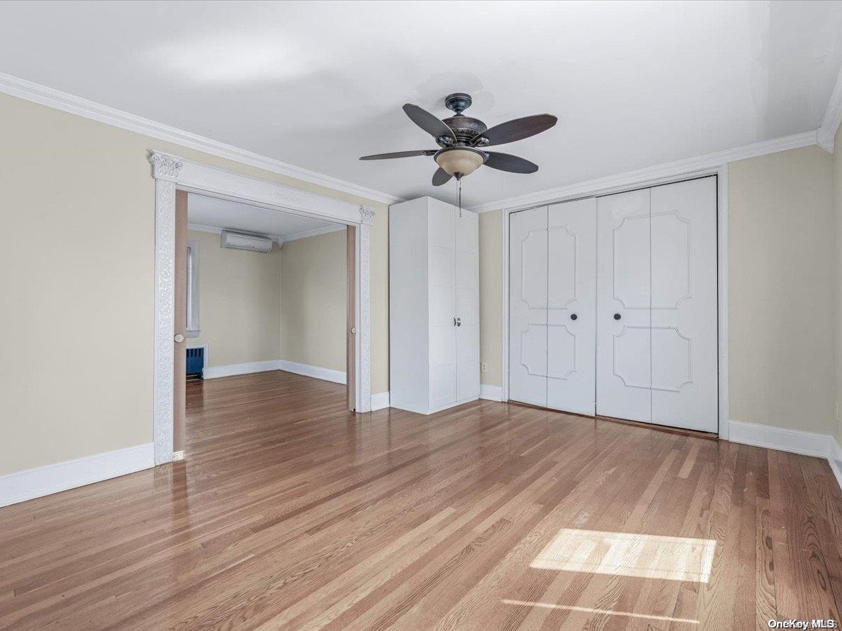 33-71 161st Street Queens, NY 11358 - Photo 12 of 35 a view of empty room with wooden floor and fan