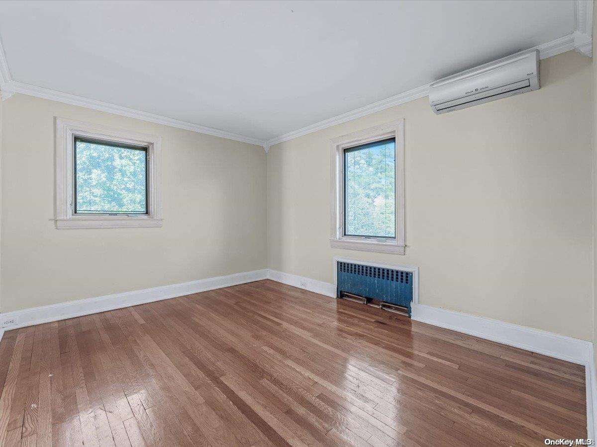 33-71 161st Street Queens, NY 11358 - Photo 14 of 35 a view of an empty room with wooden floor and a window