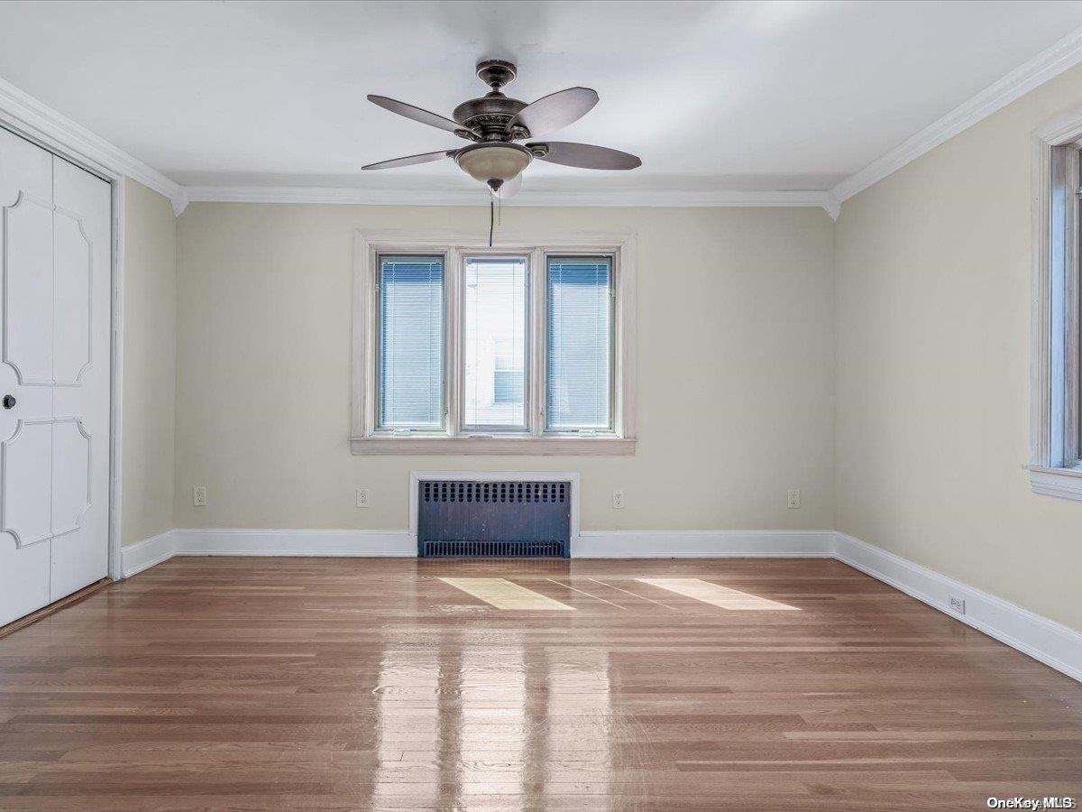 33-71 161st Street Queens, NY 11358 - Photo 17 of 35 a view of an empty room with wooden floor and a window