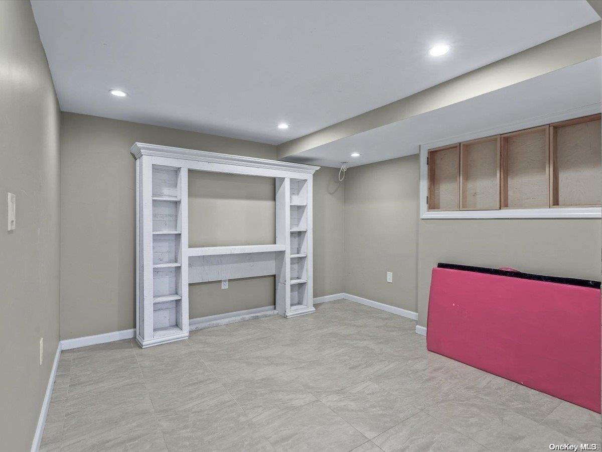 33-71 161st Street Queens, NY 11358 - Photo 30 of 35 an empty room with a fireplace and cabinet