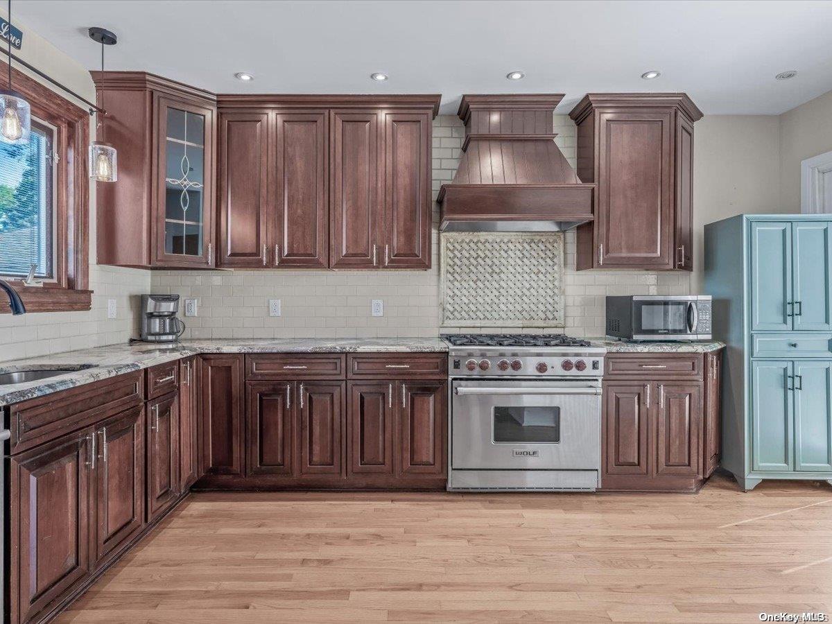 33-71 161st Street Queens, NY 11358 - Photo 8 of 35 a kitchen with stainless steel appliances granite countertop a stove a sink and a refrigerator