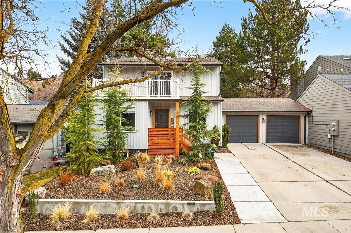 View of front of home with concrete driveway, an attached garage, board and batten siding, and a shingled roof