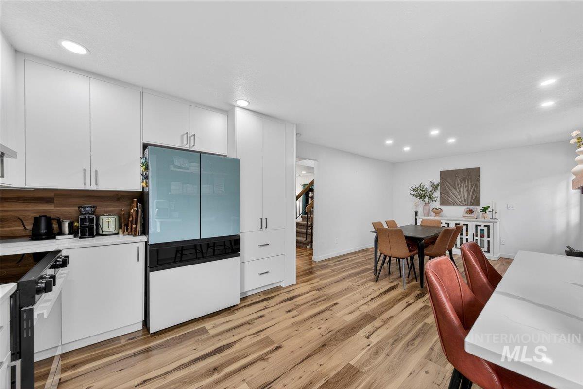 760 Meaghan Place Boise, ID 83712 - Photo 15 of 38 Kitchen with white cabinets, freestanding refrigerator, black range with electric cooktop, recessed lighting, and light wood-type flooring