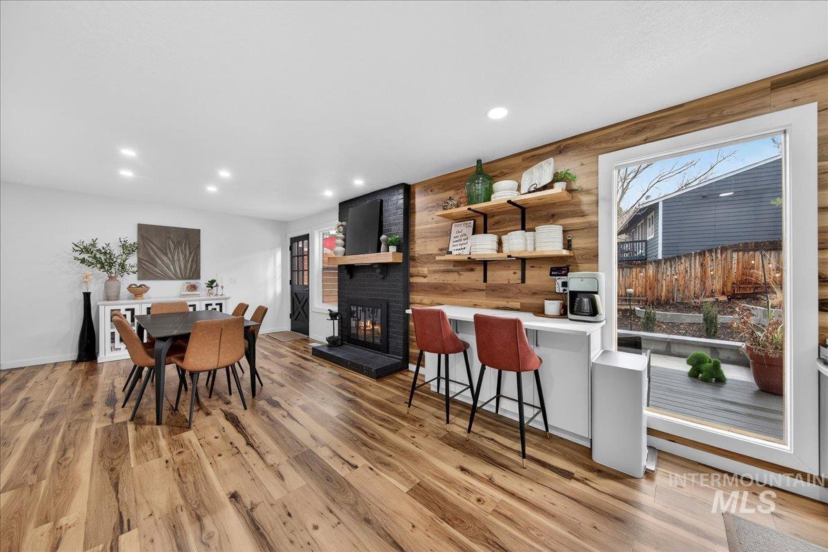 760 Meaghan Place Boise, ID 83712 - Photo 16 of 38 Dining area featuring wood walls, light wood finished floors, a brick fireplace, and recessed lighting
