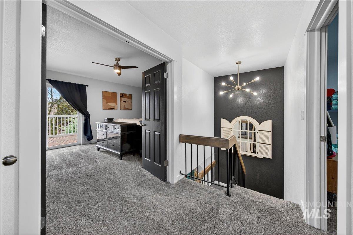 760 Meaghan Place Boise, ID 83712 - Photo 18 of 38 Hallway featuring an upstairs landing, a chandelier, carpet floors, and a textured ceiling