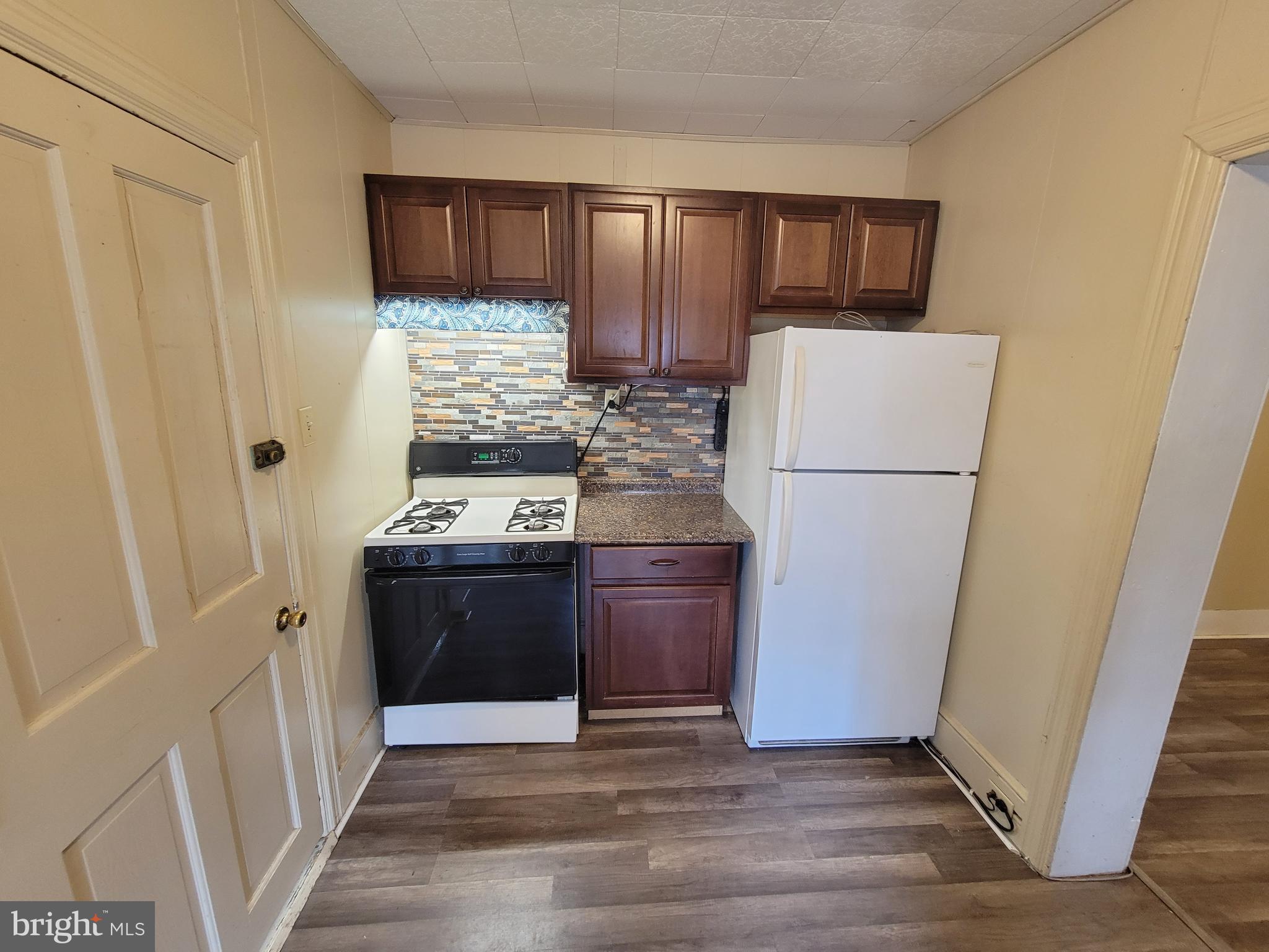 923 Walnut Street, Unit 1 Royersford, PA 19468 - Photo 13 of 14 a kitchen with a refrigerator stove and wooden cabinets