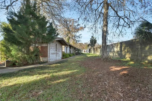 a view of a house with backyard and trees