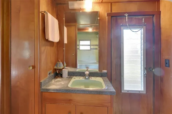 a bathroom with a granite countertop sink and a mirror
