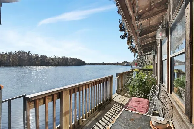 a balcony with wooden floor and lake view