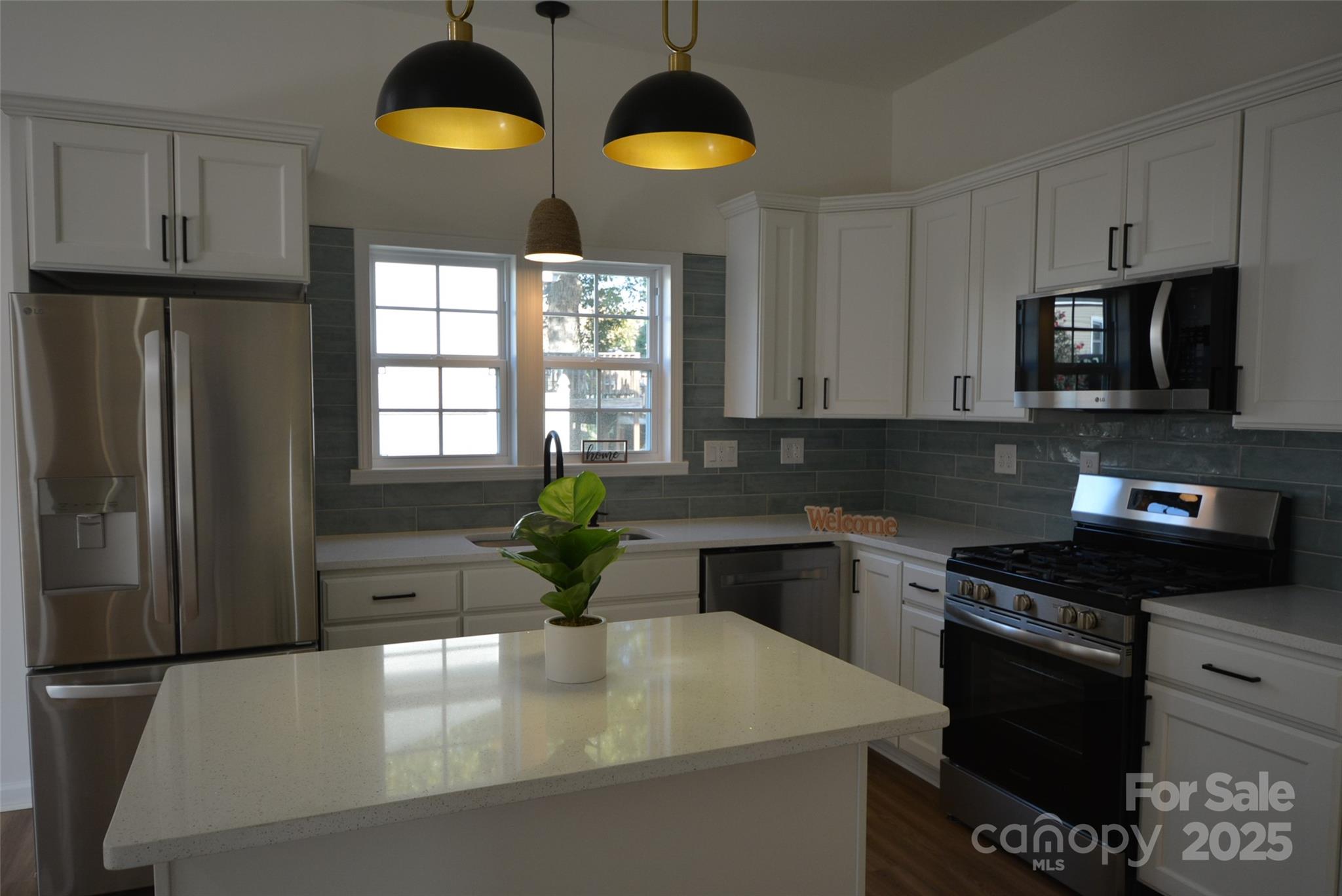 62 Fourth Street Cramerton, NC 28032 - Photo 6 of 26 a kitchen with stainless steel appliances granite countertop a stove a sink and a refrigerator