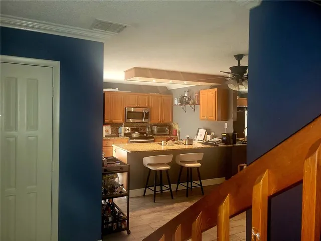 a dining hall with stainless steel appliances granite countertop furniture and a large window