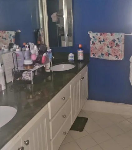 a bathroom with double vanity sink and a mirror