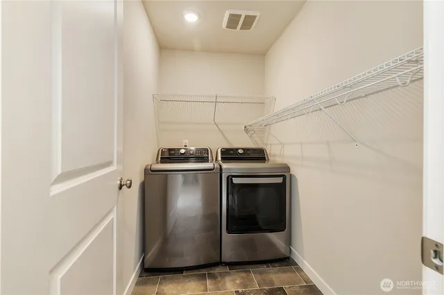 a view of a backyard with chairs potted plants and a wooden fence