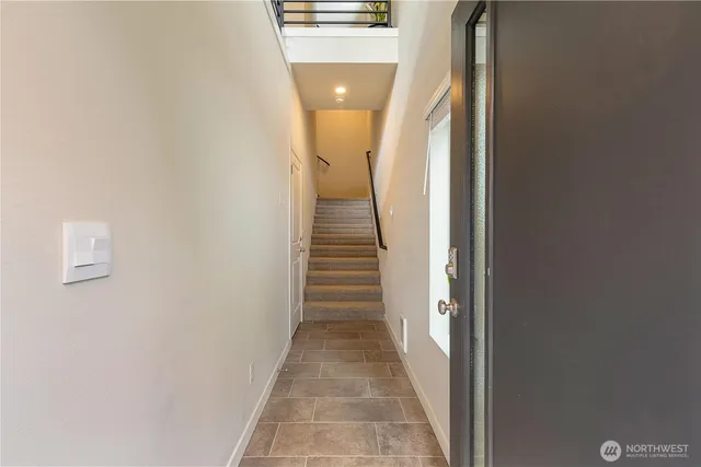 a view of a hallway with wooden floor and staircase