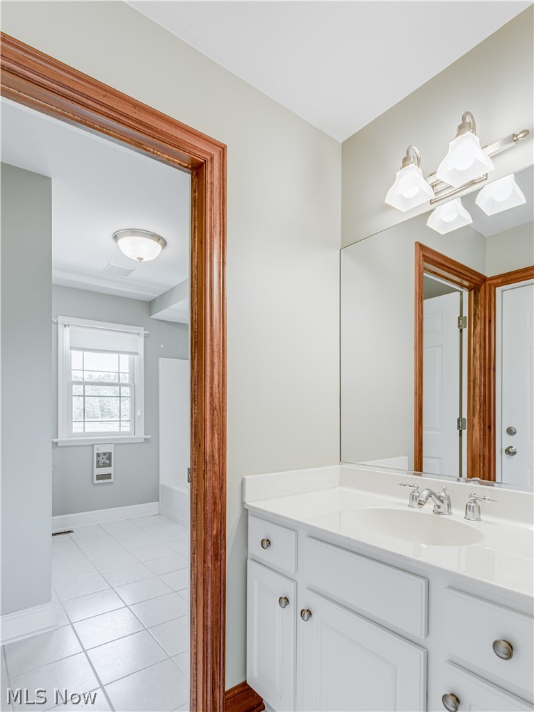 4840 Industry Road Ravenna, OH 44266 - Photo 28 of 32 Sink attached to bedroom 2 of Jack and Jill room. Entry into bath with tile floor. The door in the mirror is entry into above the garage that could be a second master, an apartment, office.....whatever the need.