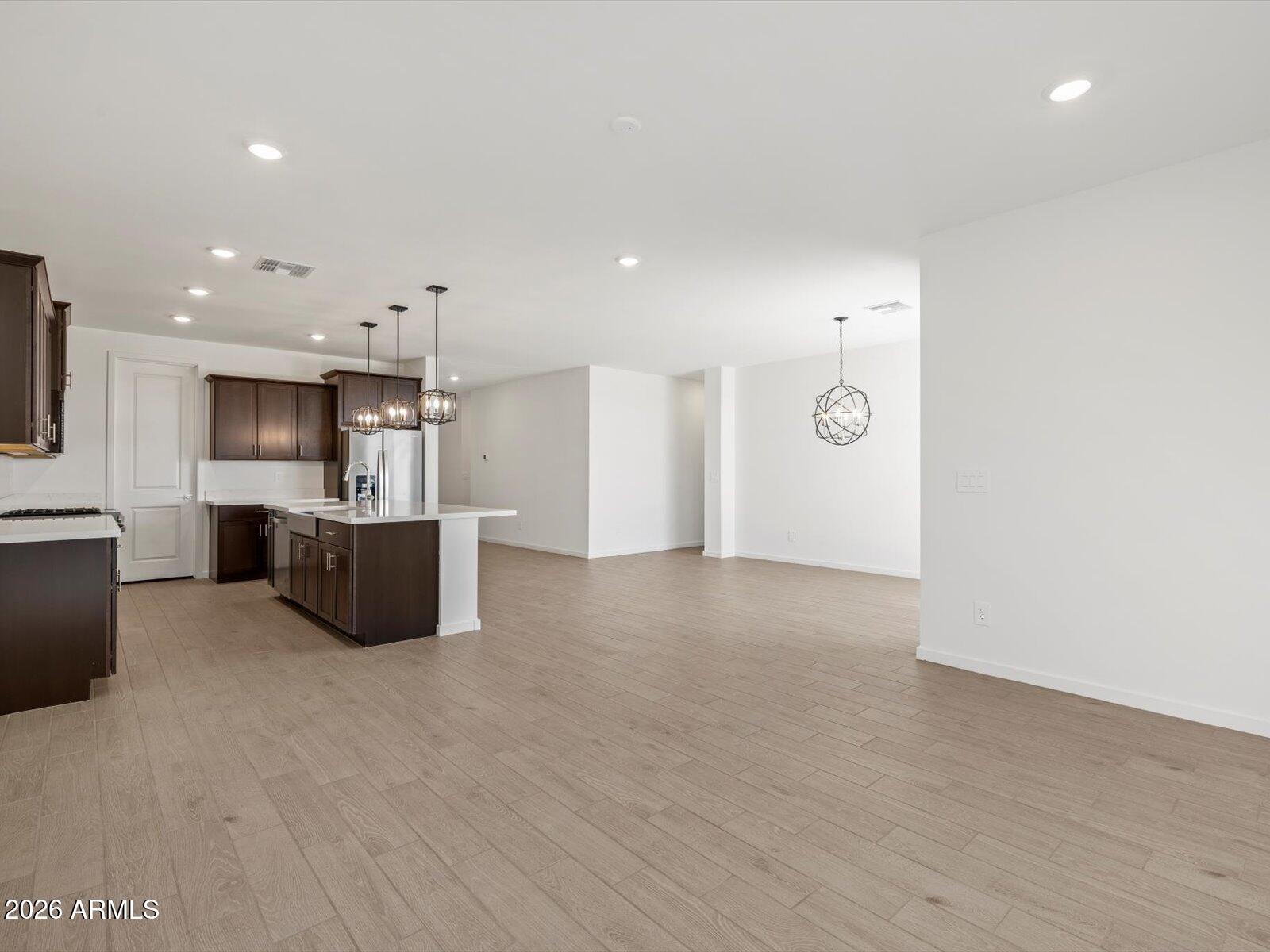 2380 Grenache Road San Tan Valley, AZ 85143 - Photo 17 of 78 a large kitchen with stainless steel appliances a large counter top a stove and a refrigerator