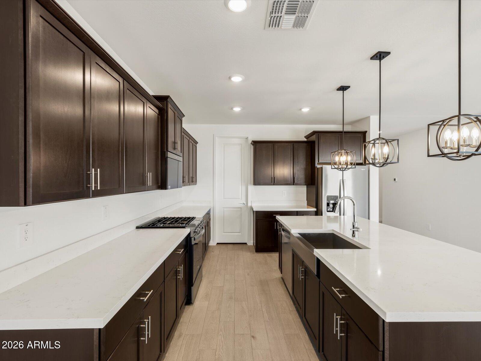 2380 Grenache Road San Tan Valley, AZ 85143 - Photo 22 of 78 a kitchen with stainless steel appliances granite countertop a sink a stove and a refrigerator