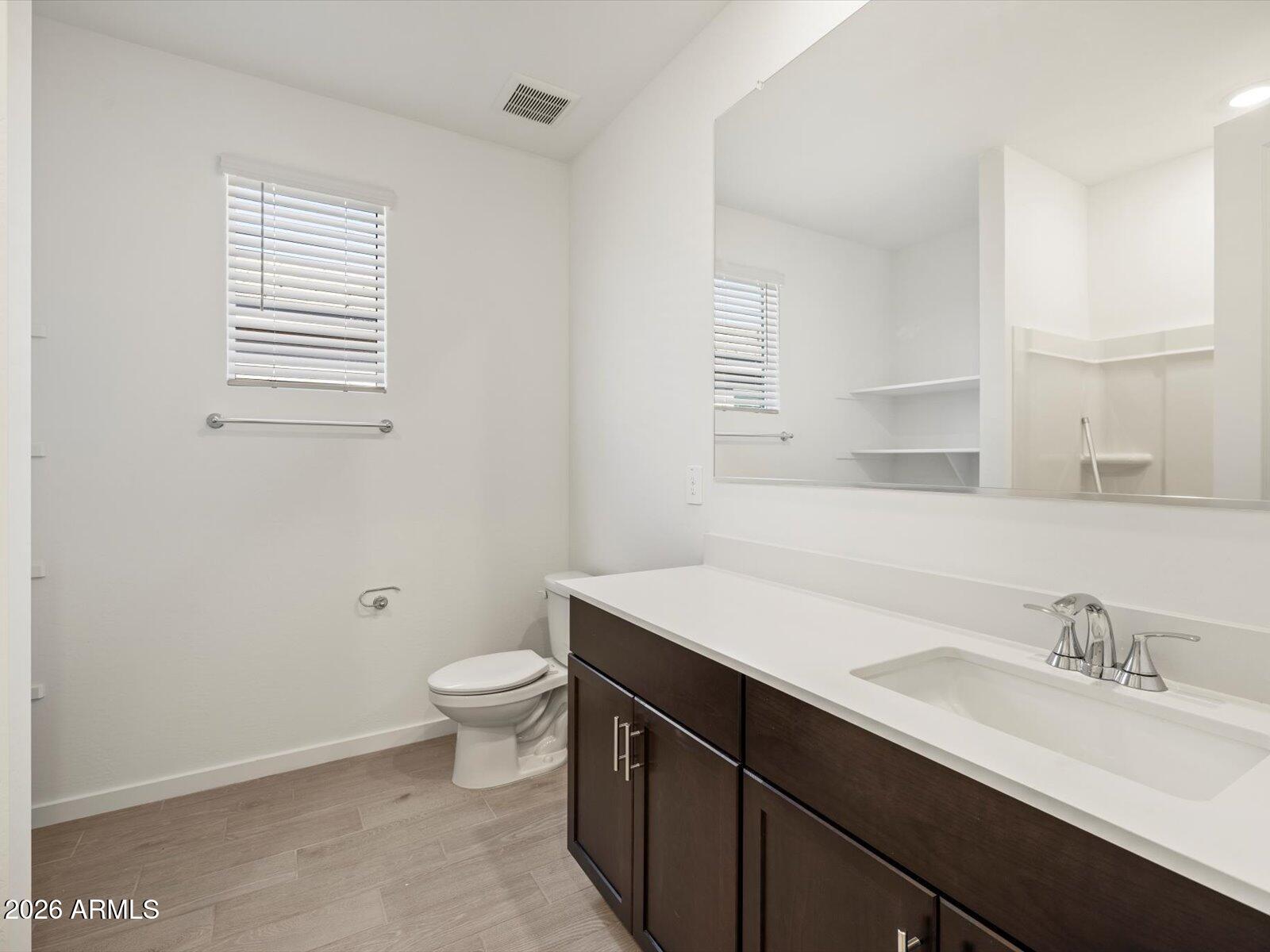 2380 Grenache Road San Tan Valley, AZ 85143 - Photo 6 of 78 a bathroom with a sink a toilet a mirror and a window