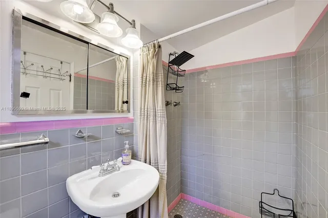a bathroom with a sink a toilet a mirror and shower