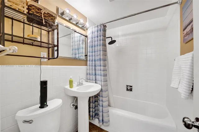 a bathroom with a sink a mirror toilet and bathtub