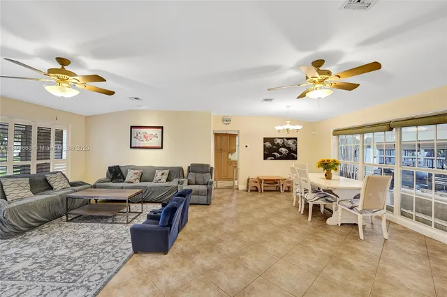 a living room with furniture potted plant and a chandelier
