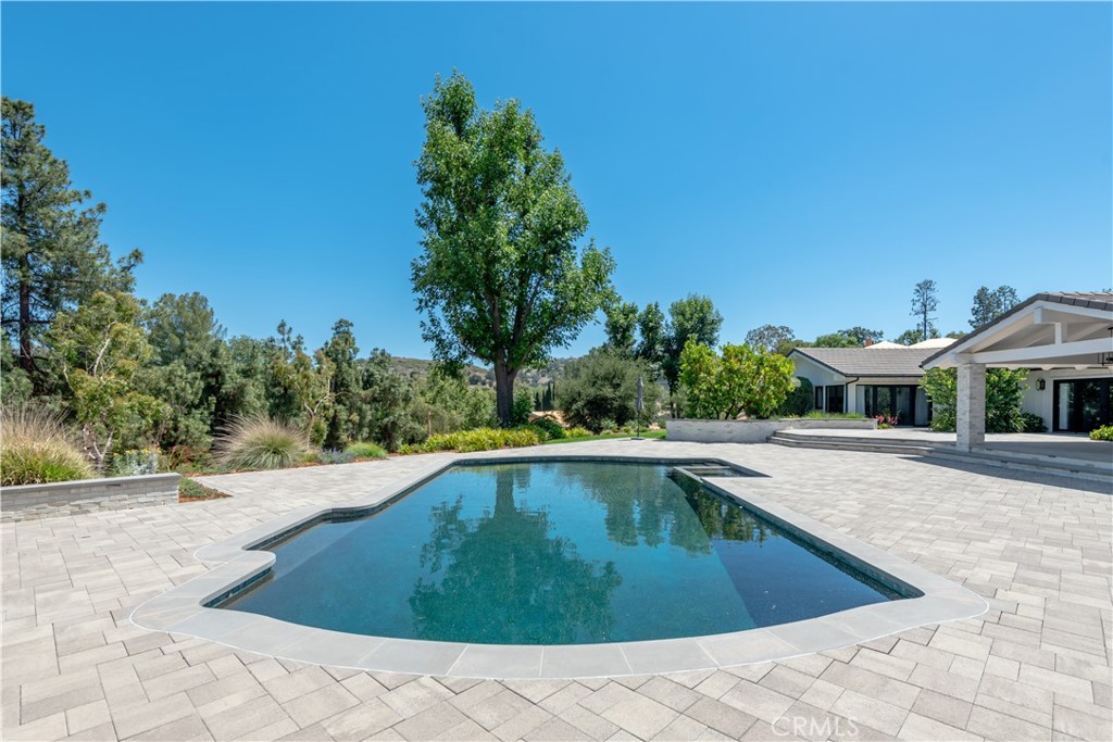 24884 Jim Bridger Road Hidden Hills, CA 91302 - Photo 28 of 31 a swimming pool with trees in the background